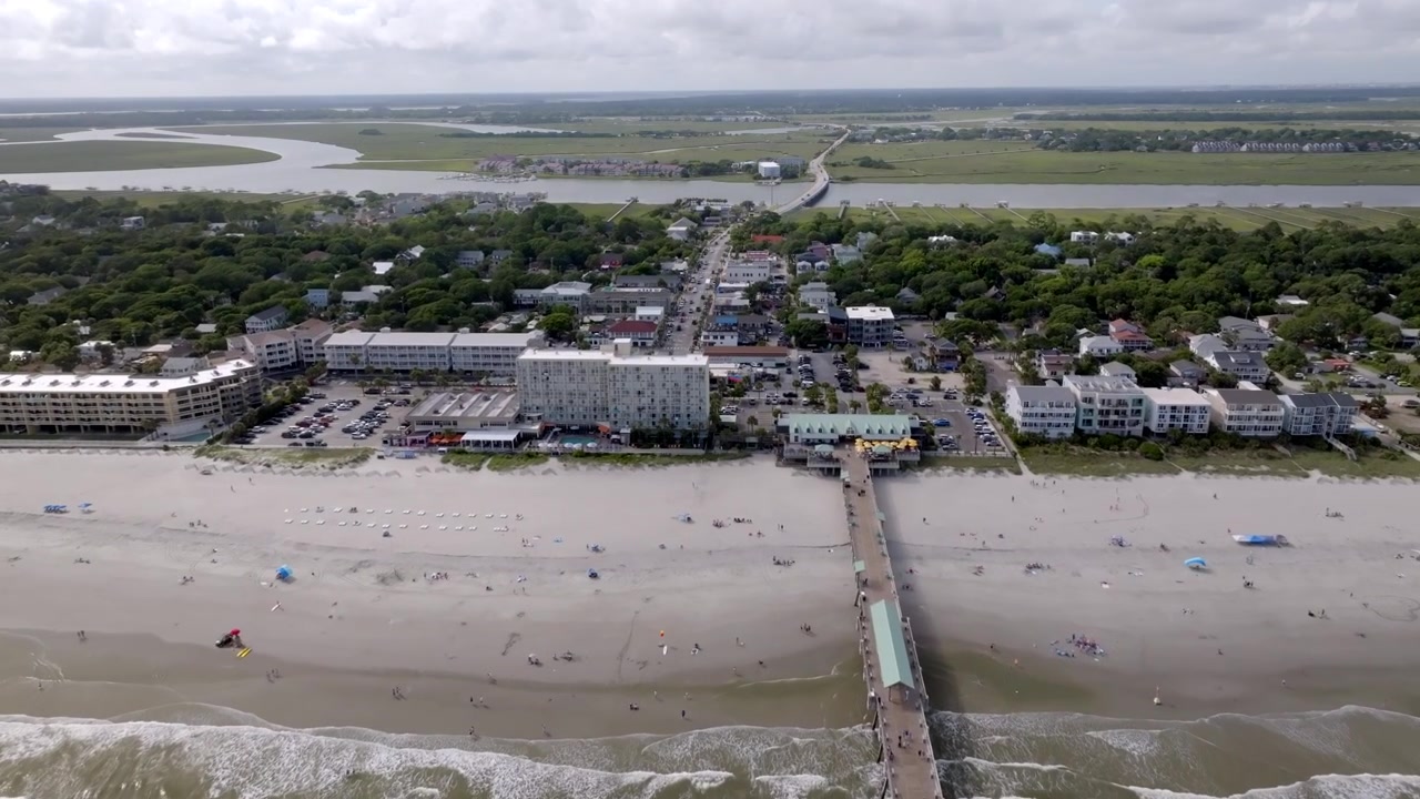 Folly Beach mole, strand, hoteller og Atlanterhavet med indkommende dronevideo