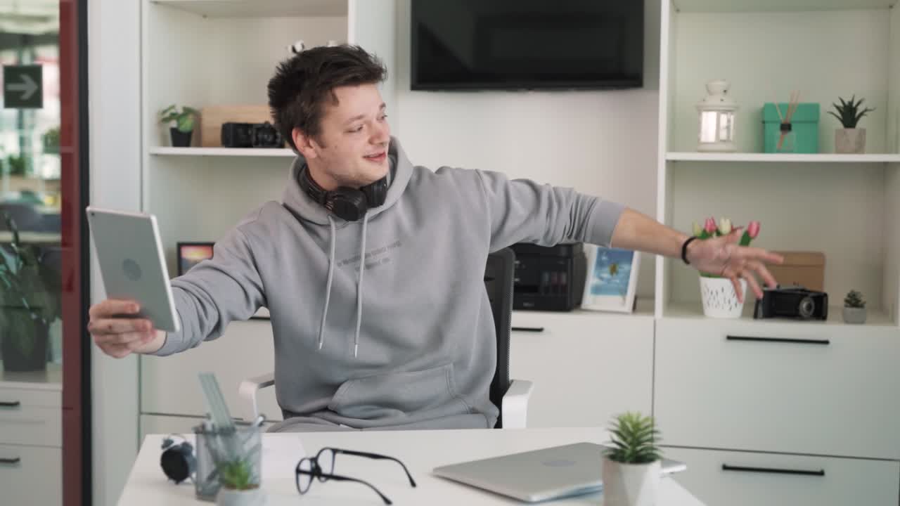 The charismatic young man, a rapper, sits in his new office, talking on his iPad and showing his conversation partner via video call his new workspace