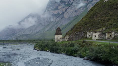 valle de montaña brumosa con antiguas estructuras de piedra