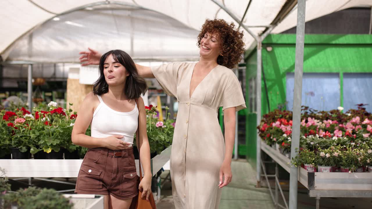 Customers hugging and smiling in greenhouse