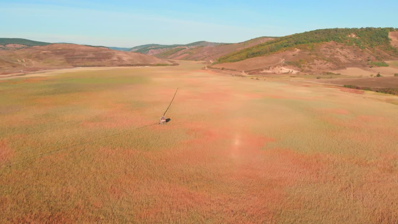 화창한 날 시골 시골의 갈색 경사진 언덕 아래 녹색과 주황색 초원 위의 전망, 공중