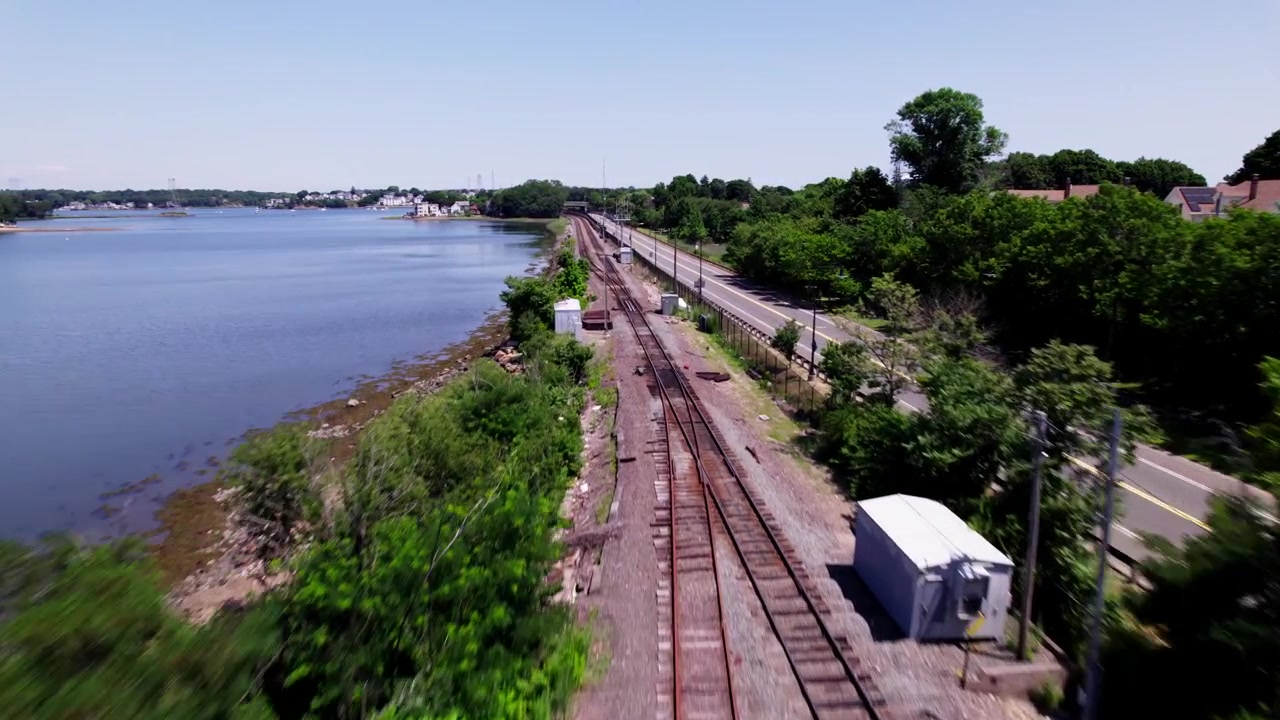 Um drone voa rapidamente ao longo de trilhos de trem de passageiros vazios em Salem, Massachusetts.