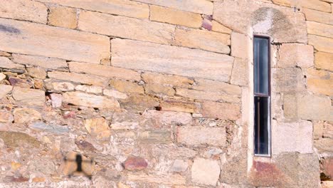 Drone-flying-next-to-a-romanesque-stone-wall