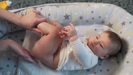 las manos de la madre masajean el culo del bebé