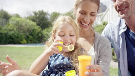 Happy-family-blowing-bubbles-in-the-yard-at-home