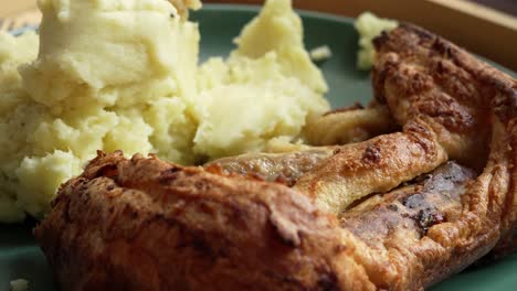 sapo de comida británico en el agujero con puré de patata en el plato