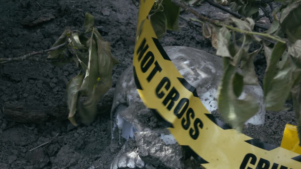 Police crime scene tape flaps over eerie Human skull found under bushes