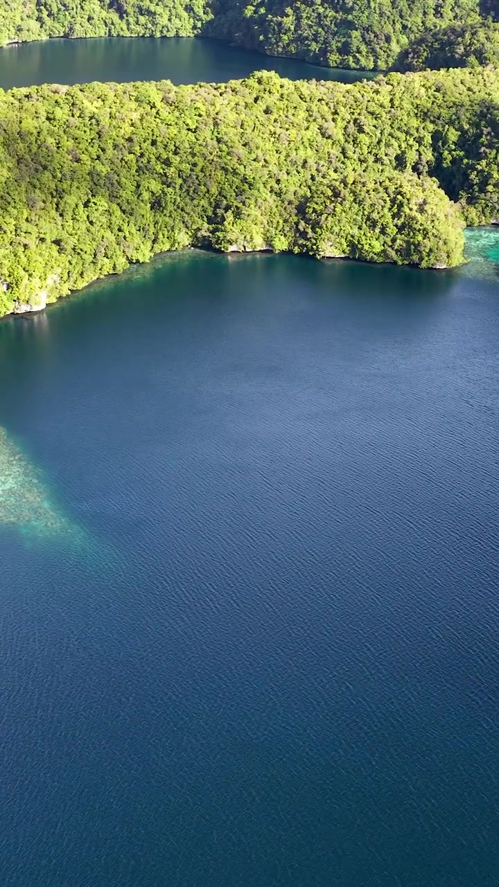 Cảnh quay drone ghi lại những hòn đảo đá vôi xanh và làn nước xanh thẳm dưới ánh nắng nhiệt đới rực rỡ.