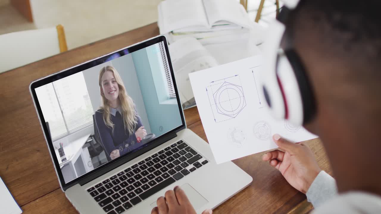 hombre de negocios afroamericano sentado en un escritorio usando una computadora portátil haciendo una videollamada con una colega