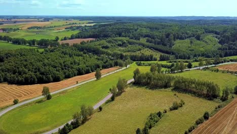 Aerial-Shot-of-Curvy-Country-Road-Surrounded-by-Fields-and-Trees