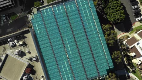 Aerial-over-large-solar-panel-on-top-of-parking-structure,-VFX-motion-graphics,-photovoltaic-concept