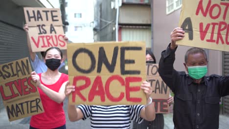 asian protesters in face masks with placards on city street