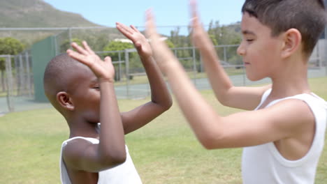 in school, children playing outside on grassy field near tennis court