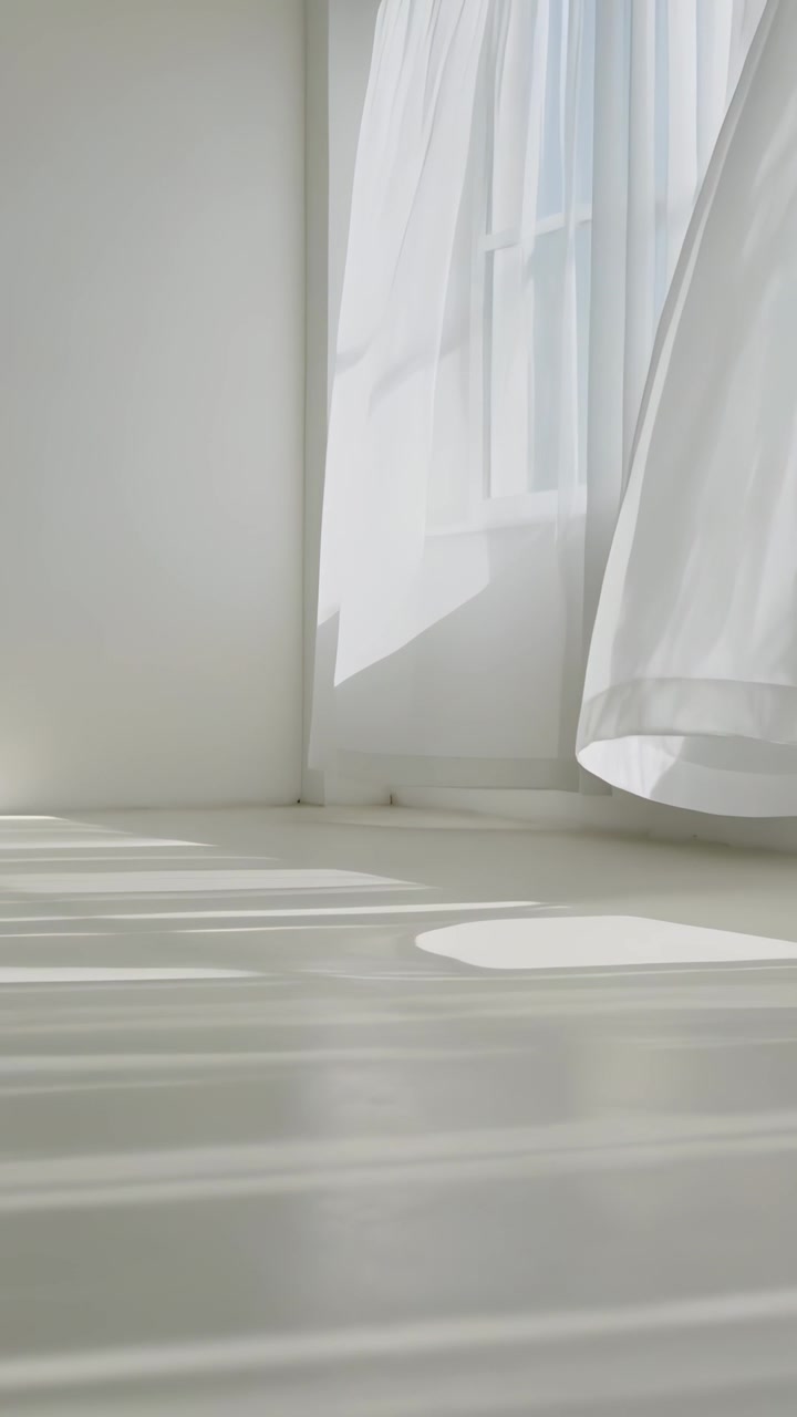 Video verticale: Tenda trasparente che ondeggia e si muove verso l'interno per una leggera corrente d'aria in uno studio bianco, con spazio per il testo