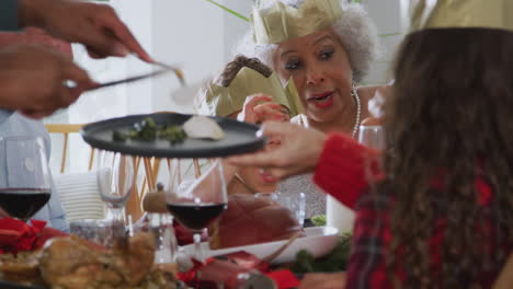 father serving food at multi-generation family christmas meal at home