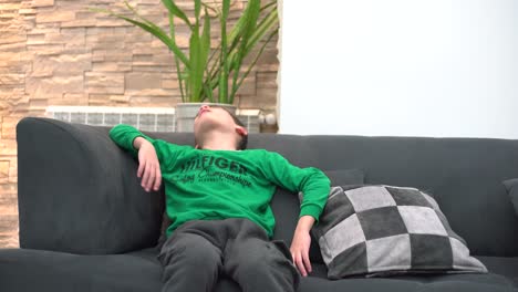 a-child-tired-in-front-of-the-TV-he-falls-asleep-on-the-sofa