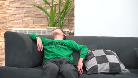 a child tired in front of the tv he falls asleep on the sofa
