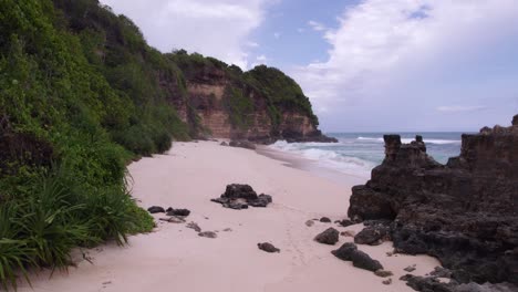 Aerial-of-Sandy-Beach-under-big-cliff-at-Sumba-island