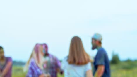 Portrait-Of-The-Attractive-Young-Joyful-Girl-Coming-Closer-To-The-Camera-And-Smiling-To-It-While-Posing-With-Many-Friends-Celebrating-Holi-Fest-On-The-Background