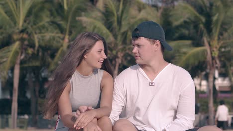 young couple communicates playing with sand in summer