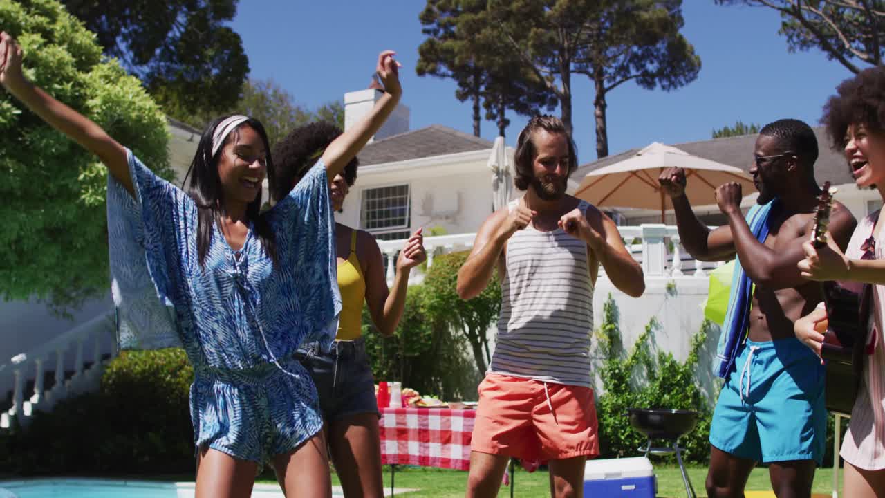 Diverse group of friends having fun and dancing at a pool party