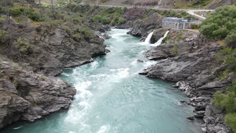 ariel footage flying up the kawarau river passed the roaring meg power station in cromwell, new zealand