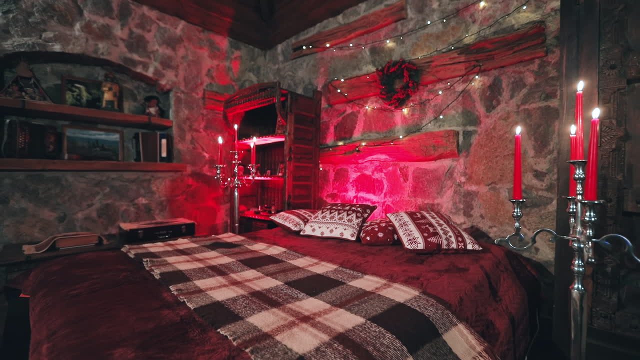 Comfortable bedroom decorated for Christmas. Large bed in cozy room with candlesticks. Romantic background in the house on winter holidays.