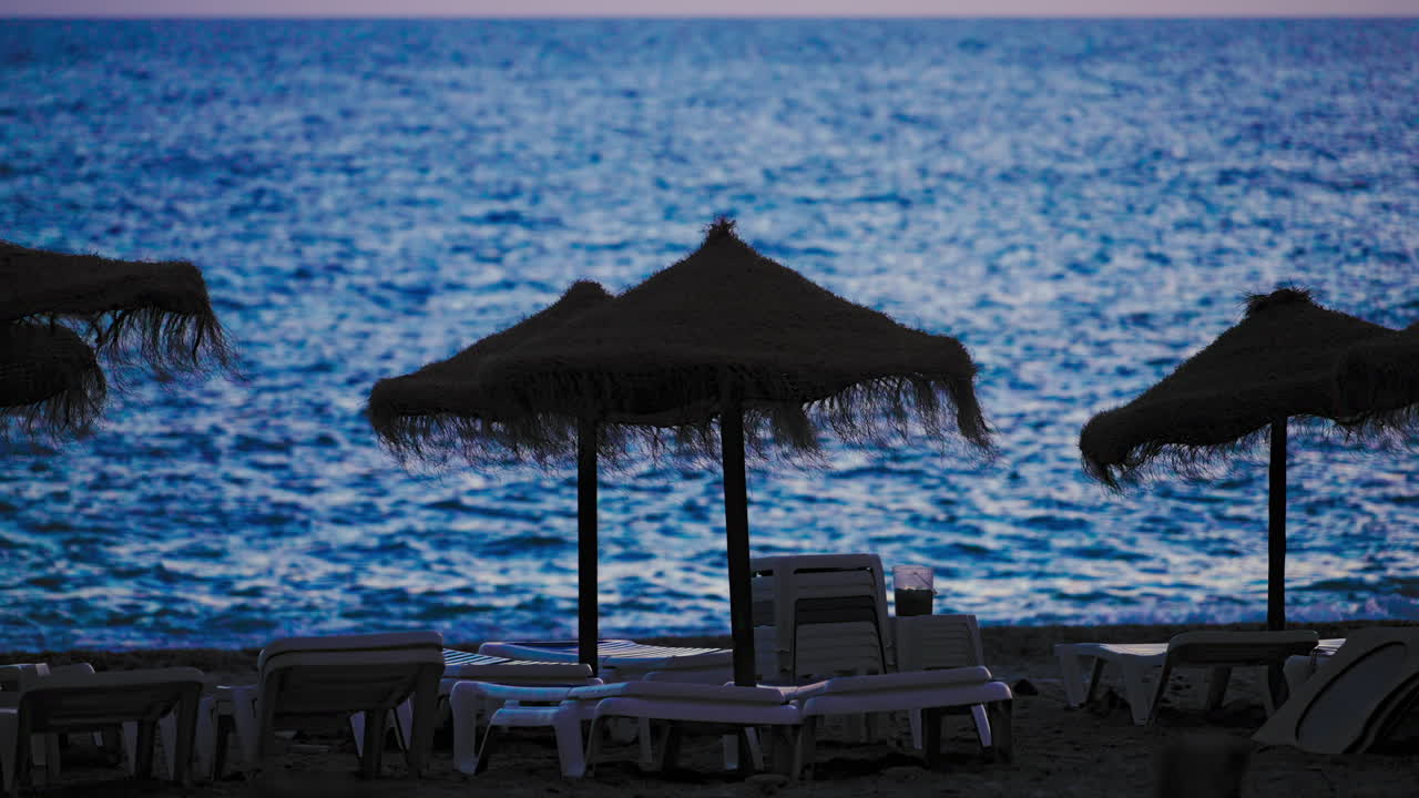 Beach sunbeds after sundown with sea on the background
