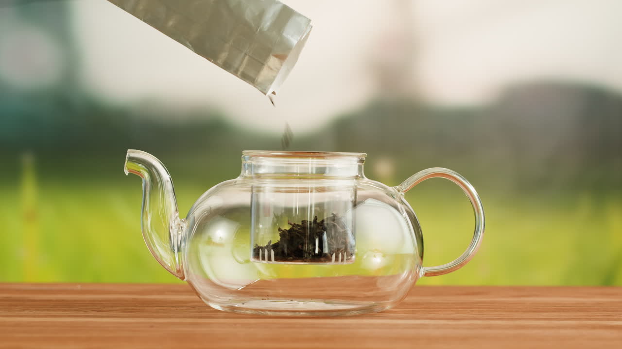 Pouring Loose Leaf Tea into a Glass Teapot