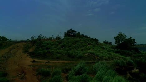 Drone-moving-forwards-and-upwards-across-grasslands-revealing-a-picturesque-Reservoir-and-a-stunning-landscape