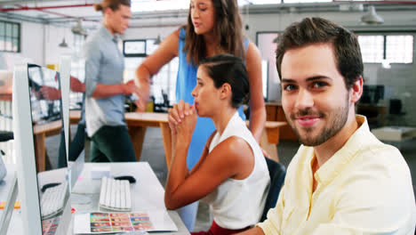 Smiling-businessman-working-on-computer-in-office