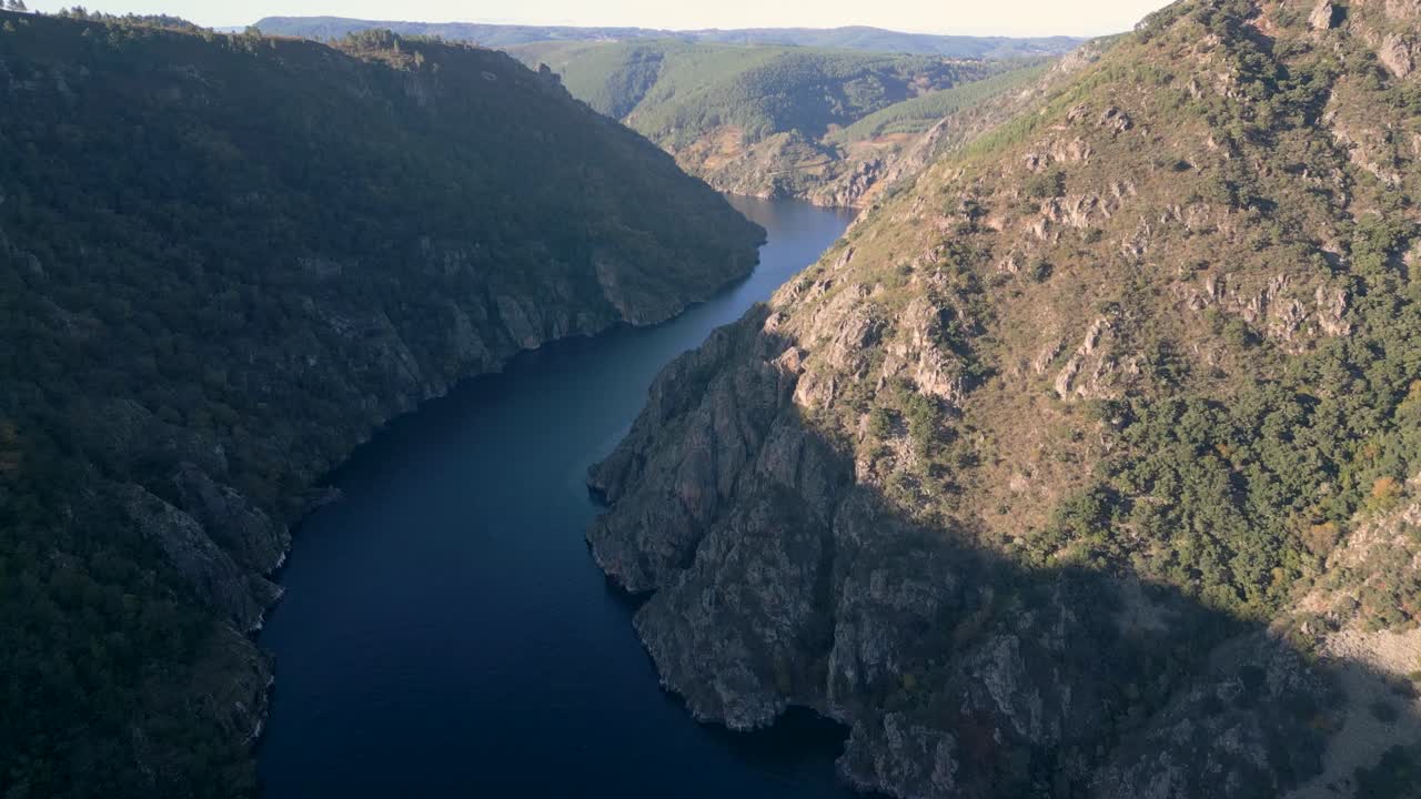 Aerial drone establishing over Cañón del Río Sil in Ribeira Sacra, Galicia, Spain, winding river between cliffs and lush landscape