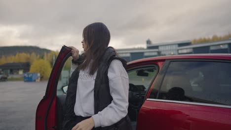 Frau-Verlässt-Ein-Auto,-Um-Ihr-Elektrofahrzeug-Aufzuladen