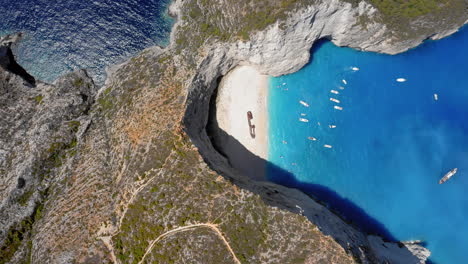 Aérea:-Toma-Panorámica-De-Arriba-Hacia-Abajo-De-La-Playa-De-Navagio-En-La-Isla-De-Zakynthos,-Grecia-Durante-El-Verano