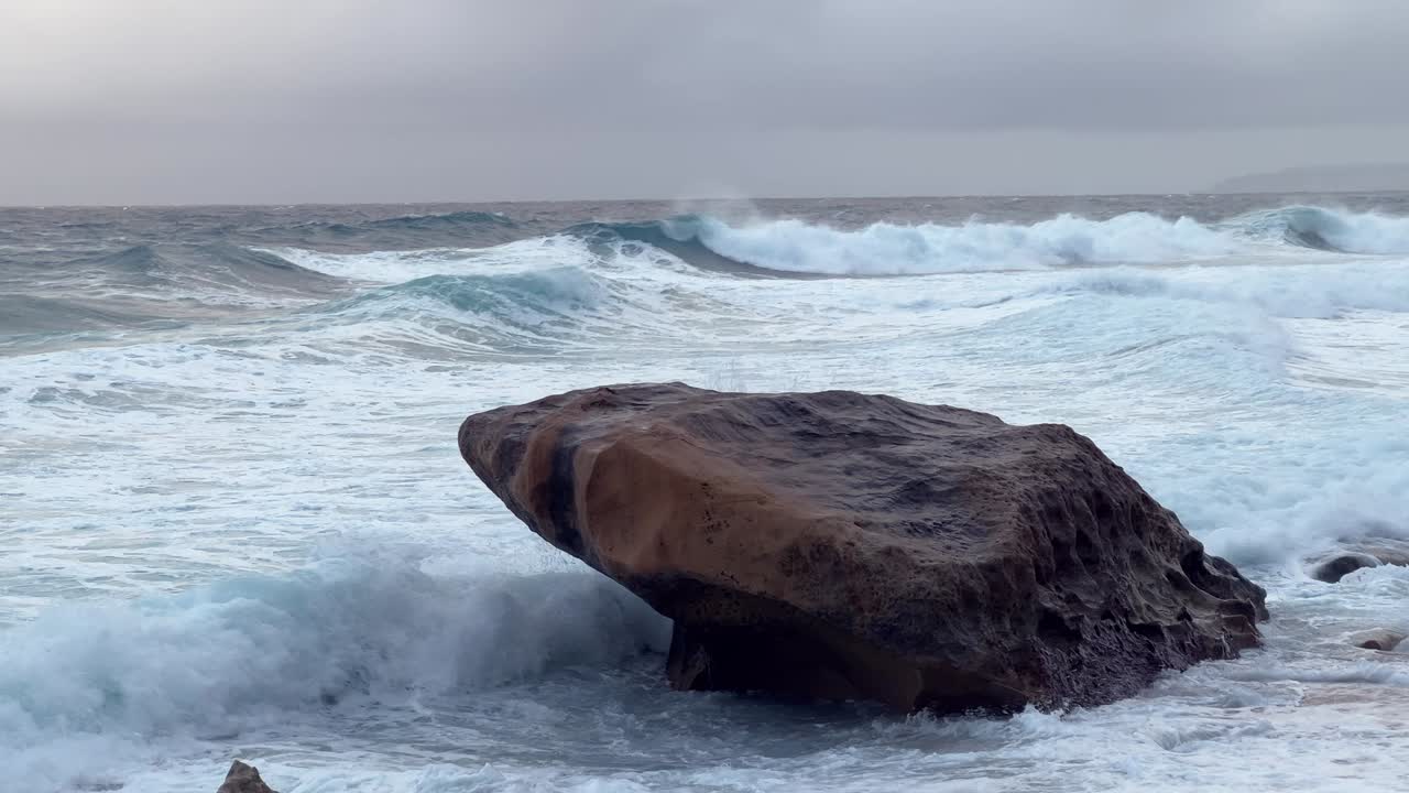 Powerful Waves Crashing Against Large Rock at Sunset