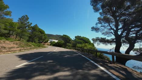 a pov shot of a cyclist cornering and descending down a twisty mountain pass at high speed, catalunya, spain