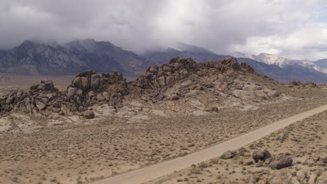 wide drone aerial above the alabama hills of california with winding dirt road for 4x4