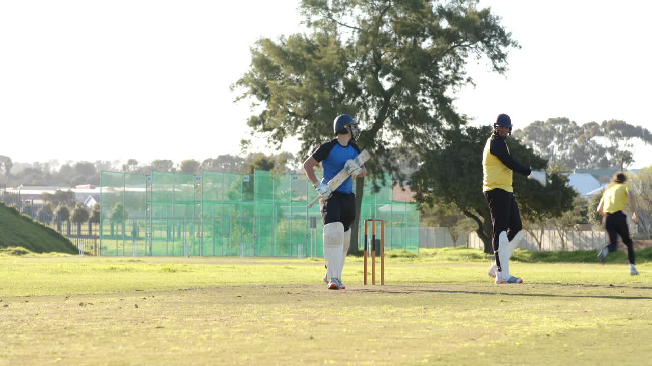 Cricket players running between wickets on sunny day, teamwork in action