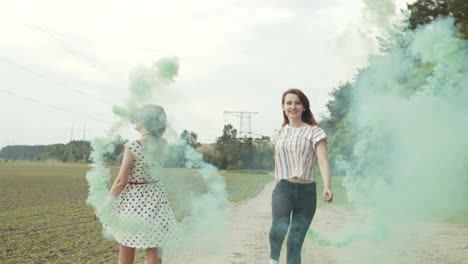 happy females with smoke bombs jumping outdoors