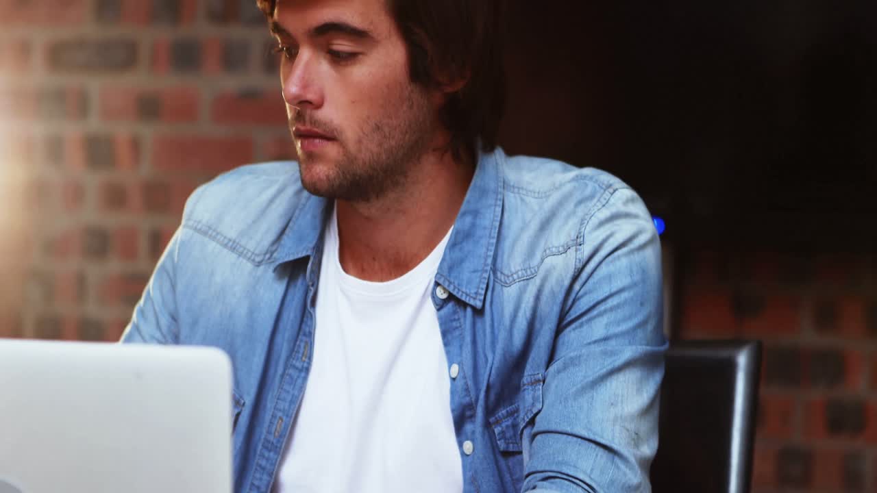 hombre tomando café mientras trabaja en la computadora portátil