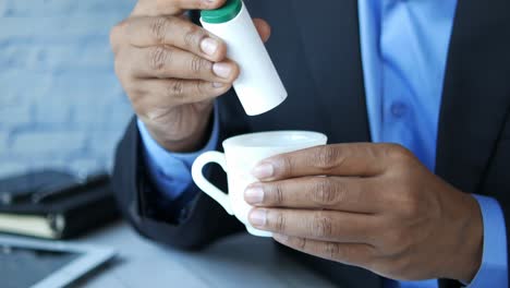 hombre añadiendo edulcorante a la taza