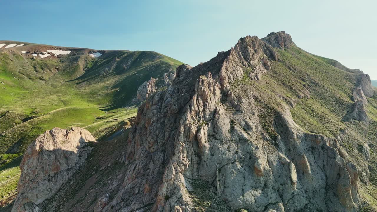 Soaring over rugged mountain peaks on a bright, sunny day in summer