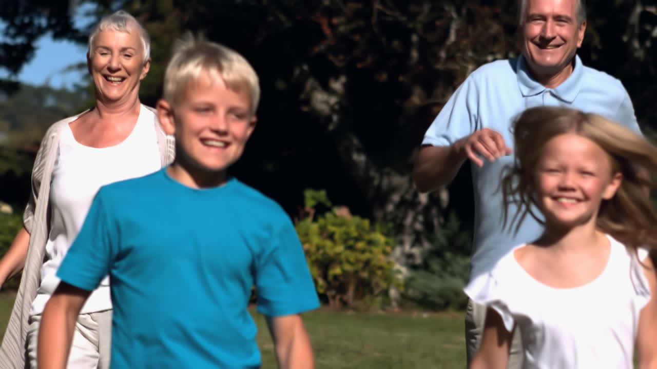 nietos corriendo con sus abuelos en un parque