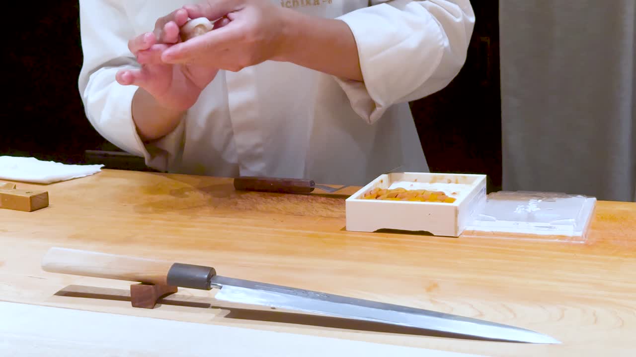 el chef prepara sushi con habilidad en un restaurante de bangkok.
