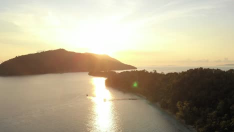 a stunning aerial view of kri island, raja ampat, indonesia, captures the golden glow of the setting sun reflecting off the calm waters