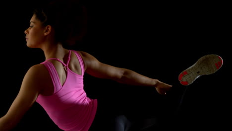 mujer en forma en rosa estirando la pierna