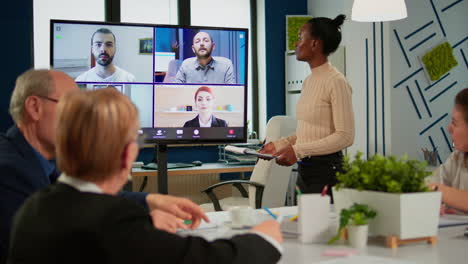 african woman discussing with remote managers on video call