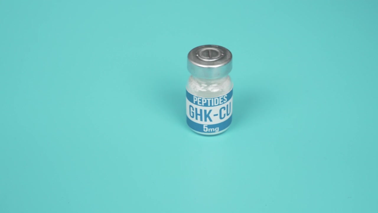 Small GHK-CU peptide vial rests on a clean turquoise surface.