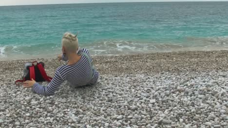 person sitting on a pebble beach