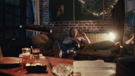 man relaxing on a couch with pizza